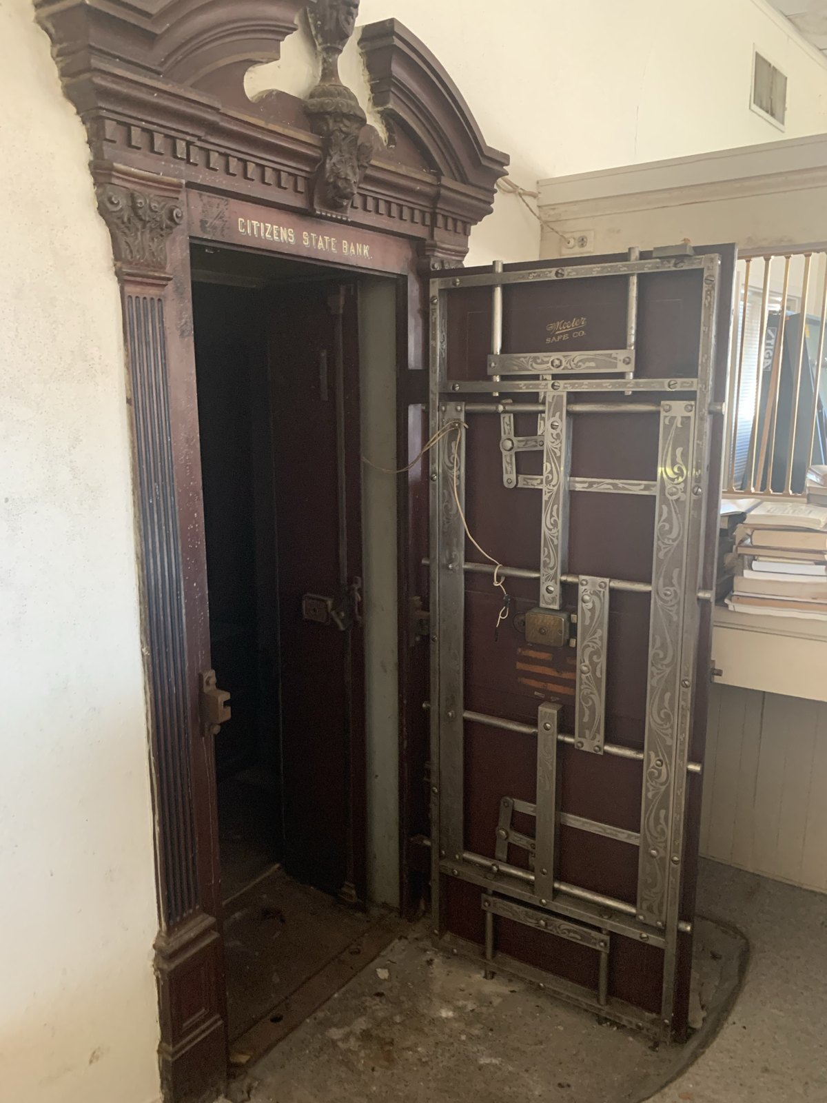 The vault, door open: the carved surround, the bank's name in gilt, and the engraved bolt work of the Mosler door.